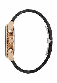 Orologio nero e oro con cassa rettangolare. Accenti in oro rosa e due pulsanti laterali. Presenta un bracciale a maglie nere.