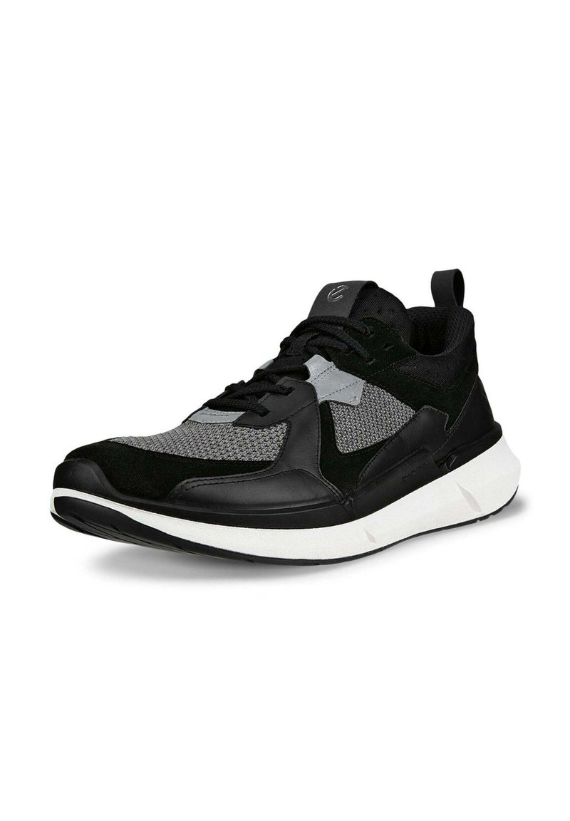 Schwarzer und grauer Sportschuh aus Mesh- und Wildledermaterialien, mit einer weißen Sohle, strukturiertem Obermaterial und kontrastierenden Akzenten.