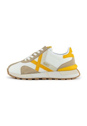 Sneakers bianchi in rete con accenti in suede beige e elementi gialli. Presentano una suola piatta in gomma, lacci tondi e un logo sul lato.