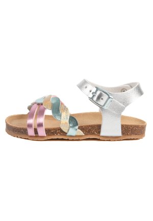 Sandale métallique avec une sangle tressée en rose, bleu et argent, un lit de pied en liège et une sangle de cheville réglable avec une boucle.