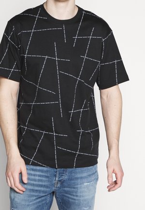 Black short-sleeve T-shirt featuring a geometric pattern of white lines and "Calvin Klein" text. Made of soft cotton fabric.