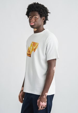Hvid bomulds-T-shirt med en grafik af en grillet ostesandwich i gule og brune nuancer, med en standard rund halsudskæring og korte ærmer.