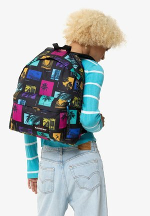 Zaino nero con stampe fotografiche tropicali colorate, dotato di tasca frontale, spallacci imbottiti e manico superiore per un trasporto facile.