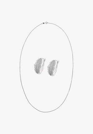 Srebrny naszyjnik z delikatnym łańcuszkiem oraz pasujące kolczyki ozdobione małymi kamieniami szlachetnymi, charakteryzujące się zakrzywionym wzorem i polerowanym wykończeniem.