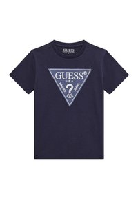 T-shirt blu navy in cotone biologico, con un'etichetta a patch bianca triangolare con testo. Maniche corte e scollo rotondo.