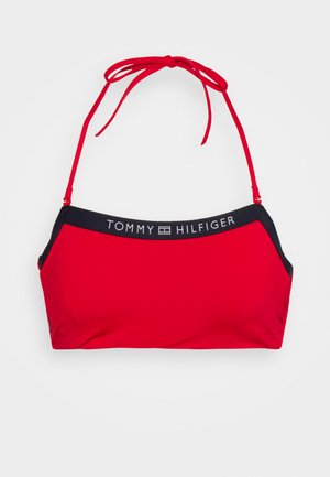 Top de bikini vermelho com alças ajustáveis vermelhas. Apresenta uma faixa azul-marinho na parte superior com a inscrição "TOMMY HILFIGER" em letras brancas. Textura suave.