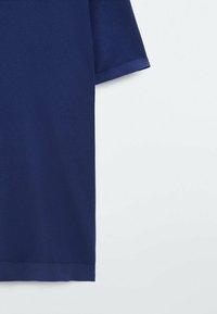 Granatowa koszulka polo z krótkim rękawem, wykonana z teksturowanej tkaniny, z klasycznym kołnierzykiem i prostym dołem o estetycznym wykończeniu.