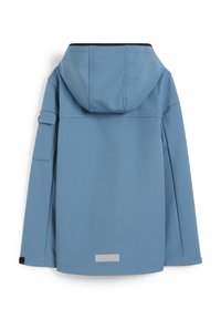 Jasnoniebieska kurtka z kapturem, o gładkiej teksturze, z zapięciem na zamek z przodu i małą kieszenią na lewym rękawie. Odbijający światło akcent na dolnym brzegu.