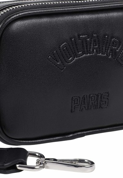 Sac en cuir noir avec le texte embossé "VOLTAIRE PARIS" et une serrure métallique argentée attachée à une sangle noire.