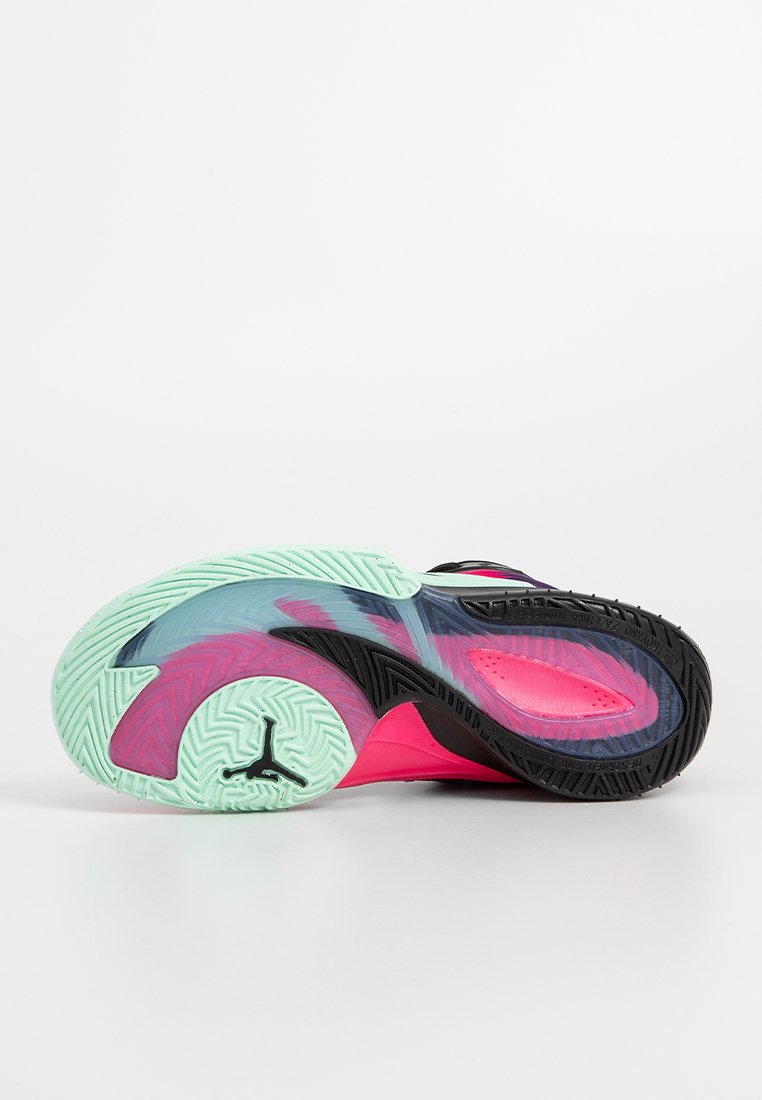 Zapatilla de baloncesto con suela de goma negra, capas superiores translúcidas en menta y rosa, y un patrón de tracción texturizado.