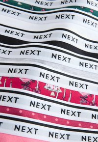 Colorful patterned waistbands stacked, featuring the brand name "NEXT" in bold black text on a white background, with varying patterns beneath.