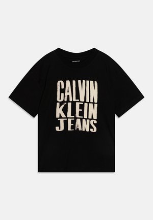 Sort t-shirt med korte ærmer med stor beige tekst ""CALVIN KLEIN JEANS"" på forsiden.