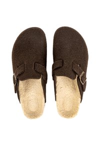 Chaussons en feutre marron avec doublure crémeuse duveteuse, design ouvert à l'arrière et deux sangles réglables avec une boucle en métal argenté de chaque côté.