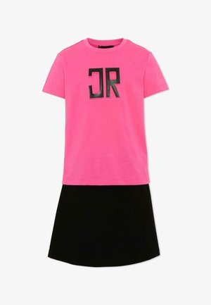 Top rosa acceso a maniche corte con lettere nere in grassetto "JR" abbinato a una semplice gonna nera al ginocchio.