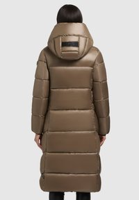 Manteau rembourré long et marron avec une finition brillante, capuche, design matelassé et détail de logo au niveau du cou. Présente une coupe droite et des poches latérales.