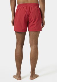 Costumi da bagno rossi con elastico in vita, realizzati in un tessuto leggero, caratterizzati da un colore uniforme e una vestibilità rilassata.