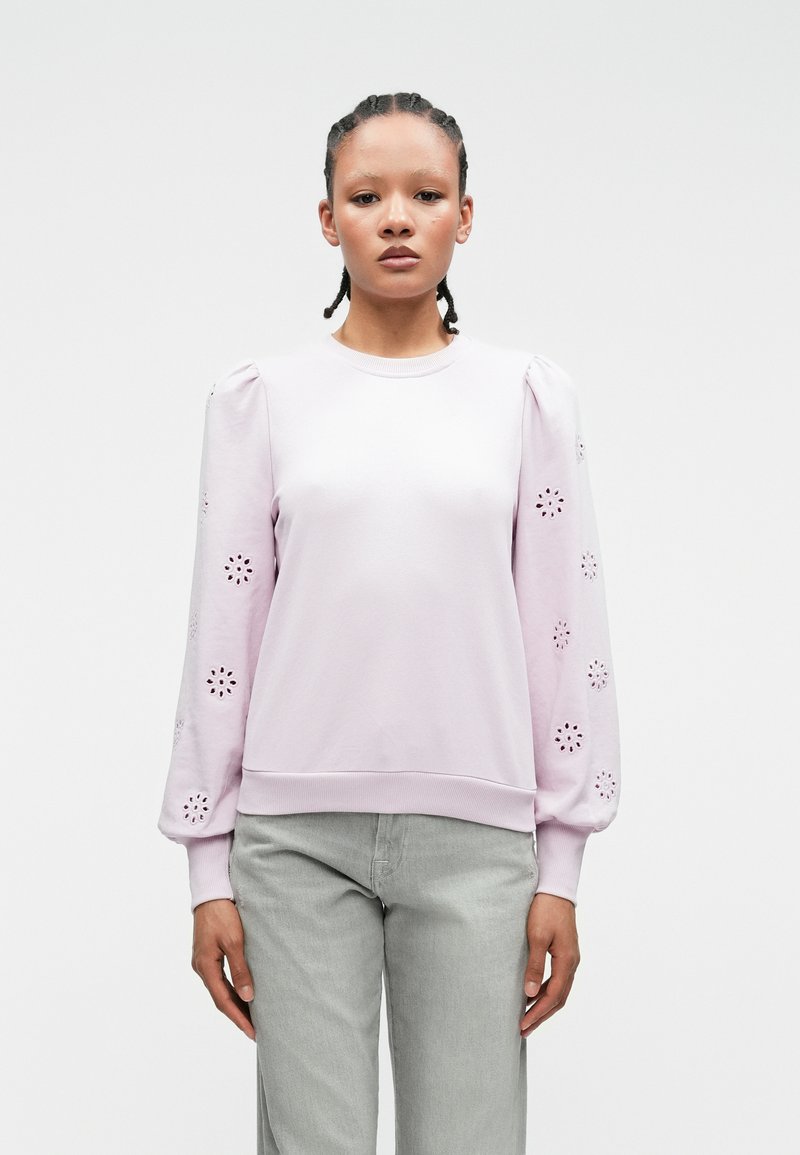 Lichtpaarse sweatshirt met opgeblazen mouwen, voorzien van bloemen uitsnijdingen. Soepele textuur met geribbelde boorden en onderrand.