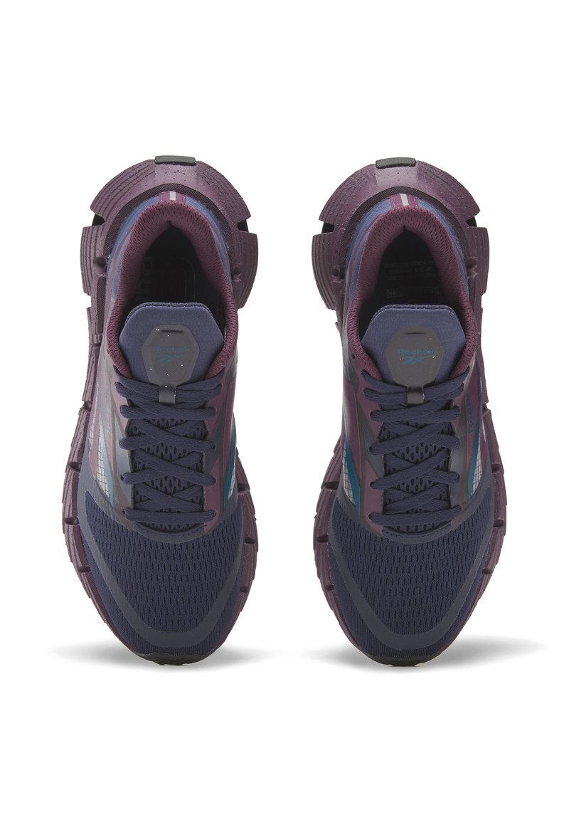 Un par de zapatillas deportivas Reebok en color púrpura oscuro y navy vistas desde arriba, mostrando los uppers de malla y las suelas texturizadas.