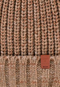 Brązowa czapka dzianinowa z teksturowanym ściągaczem, zdobiona pomarańczowymi i białymi wtrąceniami. Dołączona do niej brązowa skórzana metka z wytłoczonym napisem "BICKLEY + MITCHELL".