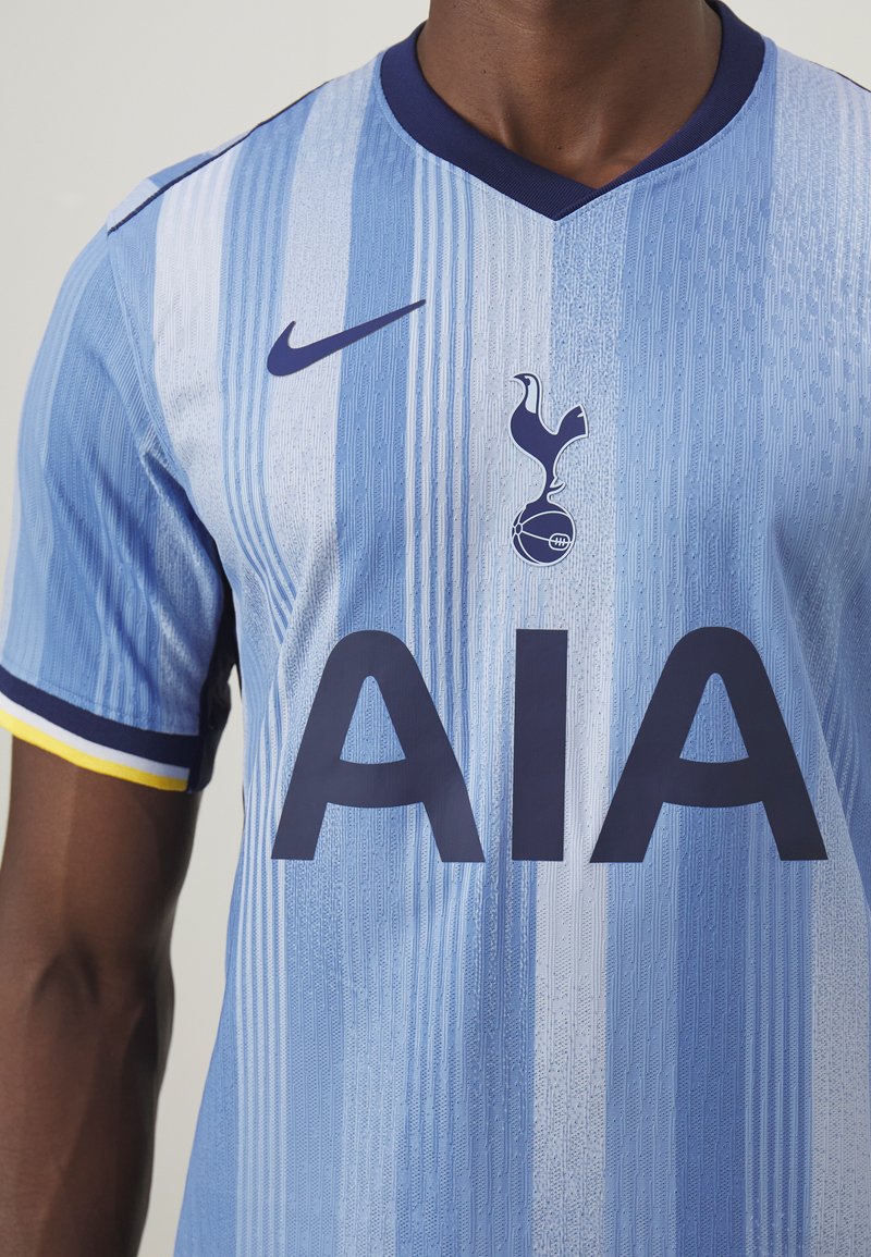 Niebieska koszulka piłkarska w pionowe paski, z granatowymi akcentami i dużymi literami "AIA". Logo Nike i herb klubu na piersi.