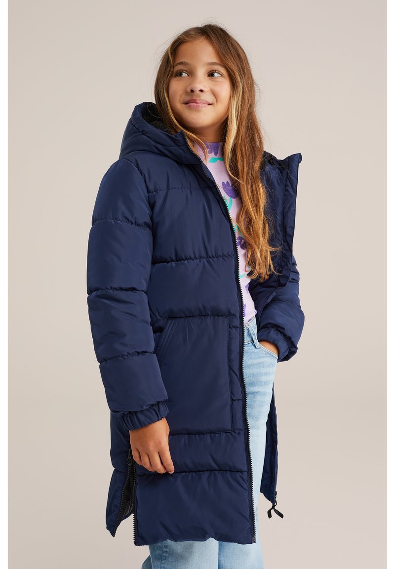 Mornarska puffer jakna s kapuco, z zadrgo in stranskimi žepi. Tkanina je gladka, oblazinjena za toploto in ima elastične manšete.