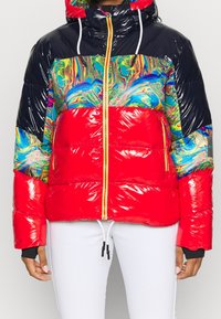 Veste rouge duveteuse ornée d'un motif marbré coloré, avec une texture brillante, une capuche et des accents noirs. Fermeture éclair avec des détails jaunes vifs.