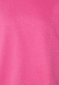 Camiseta de manga corta y cuello redondo en rosa brillante, hecha de una suave mezcla de algodón con una textura sólida y uniforme. Sin patrones ni acentos.