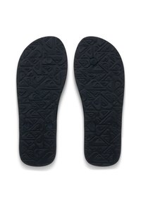 Μαύρες καουτσούκ εσωτερικές σόλες με υφασμένα μοτίβα, που διαθέτουν ανυψωμένα γεωμετρικά σχήματα και έναν κυκλικό διακοσμητικό στοιχείο κοντά στην περιοχή της φτέρνας.