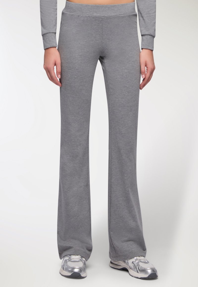 Pantaloni sportivi grigi a zampa d'elefante realizzati in morbido tessuto misto cotone con cintura elastica. Texture liscia, vestibilità casual, adatti per attività di svago.