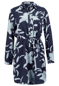 Robe chemise bleu marine à motif floral blanc, manches longues, boutonnée sur le devant, poche poitrine et ceinture à nouer à la taille.