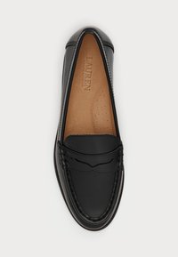 Čierne kožené mokasíny s okrúhlou špičkou, dekoratívnym prešívaním a mäkkou hnedou vnútornou stielkou s malými perforáciami na zabezpečenie priedušnosti.