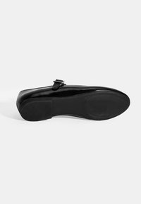 Schwarzer Lackleder-Schuh mit glatter Oberfläche, abgerundeter Spitze und einem kleinen verstellbaren Riemen mit Schnalle. Strukturiert, gummierte Außensohle mit Griffmuster.