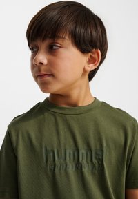 Oliveworo bawełniana koszulka z krótkim rękawem, z okrągłym dekoltem, z teksturowanym logo "hummel SPORTSWEAR" w ciemniejszym odcieniu.