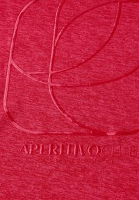 Červená tkanina s hladkým, raženým designem loga "APERITIVO CLUB" a vrstveným vzorem kruhů, který vytváří jemnou variaci textury.