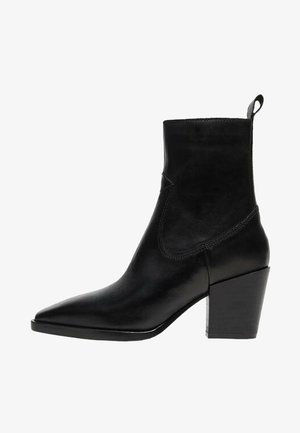 Bottine noire à bout pointu avec talon bloc et languette de tirage, finition cuir lisse, détails de coutures latérales.