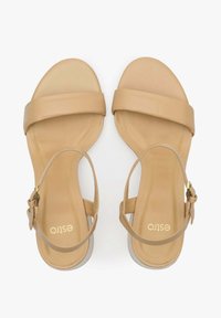 Brązowe skórzane sandały z płaską podeszwą, szerokim paskiem z przodu i regulowanym paskiem na kostkę z detalem w postaci złotego zapięcia.