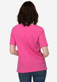 Korte mouwen roze t-shirt van zachte katoen, met een klassieke pasvorm en een eenvoudige halslijn. De achterkant heeft een gladde textuur en geen patronen.