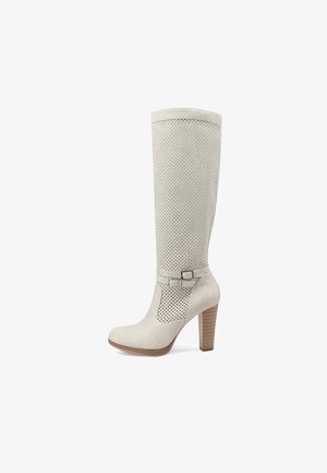 Stivale beige a metà polpaccio con tacco, tomaia traforata, due fibbie laterali decorative e tacco a blocco impilato in legno.