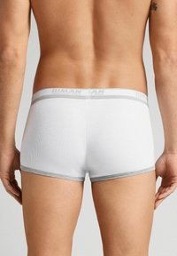 Białe prążkowane bokserki z szarym elastycznym paskiem, na którym znajduje się napis "HUMAN" w jasnoszarym kolorze. Gładka tekstura, dopasowany krój.