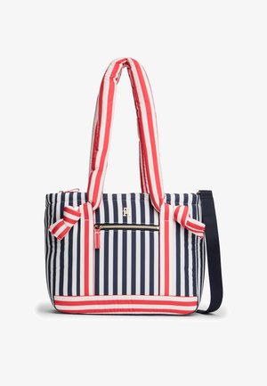 Bolso tote a rayas con franjas verticales y horizontales en azul marino, blanco y rojo, asas acolchadas, bolsillo frontal con cremallera y correa de hombro desmontable.