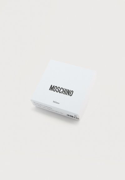 Λευκό κουτί Moschino Milano με μαύρο κείμενο σε ανοιχτό φόντο, που δείχνει τον γραμμωτό κώδικα προϊόντος στη κάτω πλευρά.