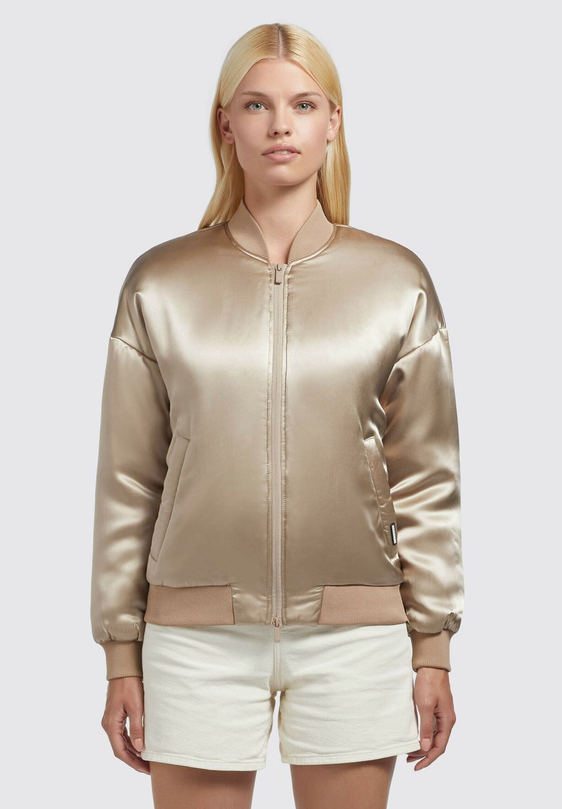 Satin bomber jakna v svetlo zlati barvi z zadrgo spredaj, rebrastimi manšetami in obrobo. Ima stranske žepke in mehak, gladek material.