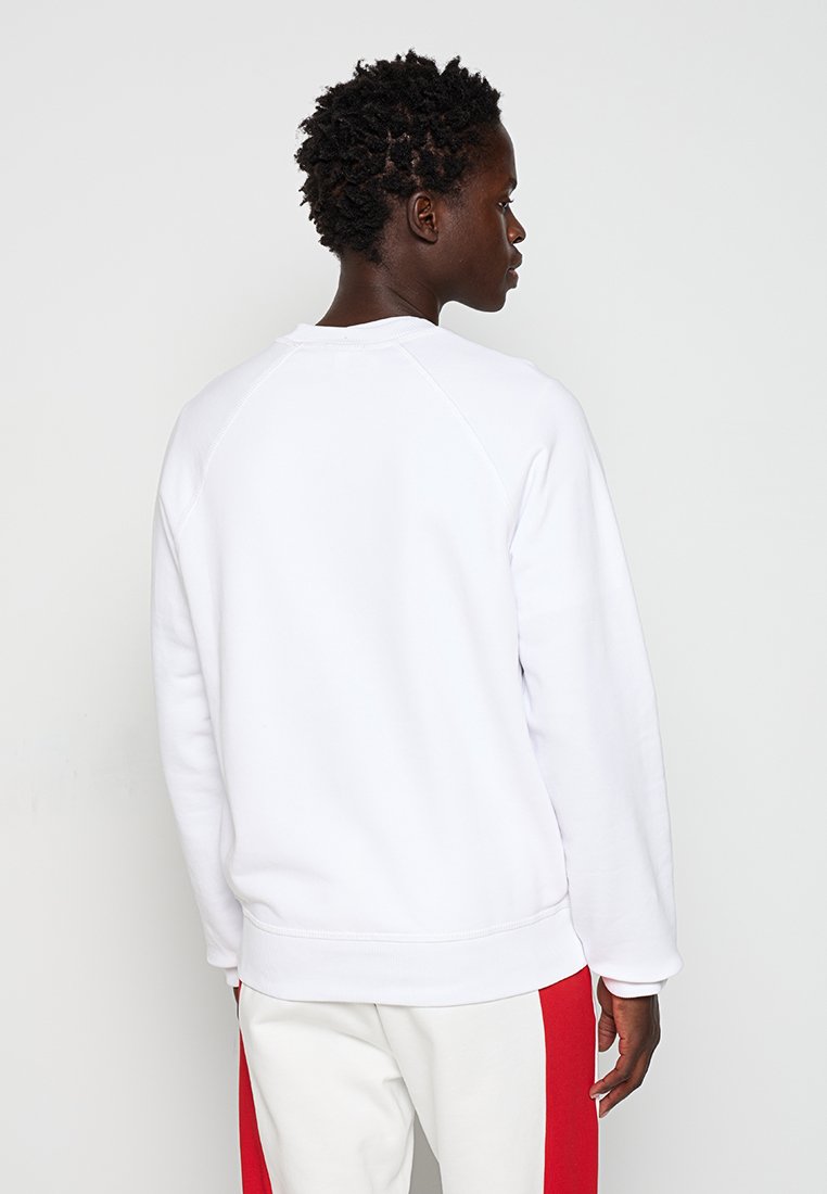 Weißer Baumwollpullover mit Raglanärmeln, rundem Ausschnitt und lockerer Passform. Glatte Textur mit gerippten Bündchen und Saum.