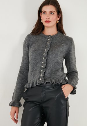 Grijze gebreide cardigan met een ronde halslijn, een decoratieve ruffle zoom en een knopenfront. Heeft lange mouwen en een gestructureerde stof.