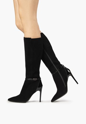 Sorte over-kneeboots i ruskind, med en høj stilettohæl, spids tå og blanke patentlæderdetaljer samt en lynlås på siden.