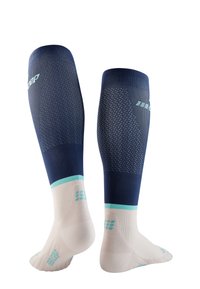Kompressionssocken mit einer Farbgebung in Marineblau und Weiß, ausgestattet mit strukturiertem Strickobermaterial und geripptem Design sowie gepolsterten Sohlen in Hellblau.
