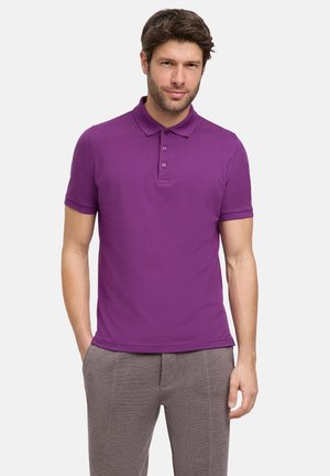 Paarse polo shirt met een drievoudige knoopsluiting en korte mouwen, gemaakt van gladde, ademende stof; gecombineerd met lichtgrijze broeken.