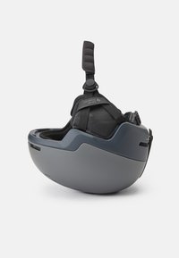 Casco protector gris con una forma suave y redondeada, equipado con una correa ajustable acolchada y forro de malla para mayor comodidad.