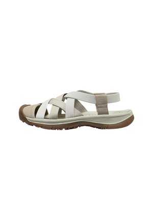 Sandalo beige e marrone con punta aperta, cinturini incrociati in tessuto e suola in gomma testurizzata, progettato per comfort e supporto all'aperto.