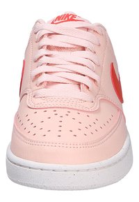 Sneakers Nike in morbido pelle rosa con finitura testurizzata, caratterizzate da dettagli rossi e foro sulla punta. Suola in gomma bianca.